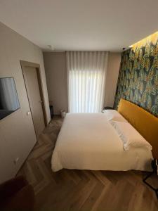 a hotel room with a large bed and a television at Telese Charme B&B in Telese