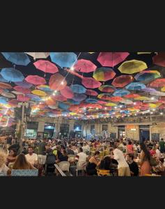 Testa House في كاتانيا: مجموعة كبيرة من الناس يجلسون على الكراسي تحت المظلات