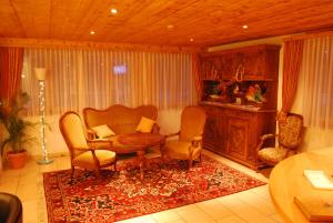 a living room with a couch and chairs and a table at Hotel Fiescherhof in Fiesch