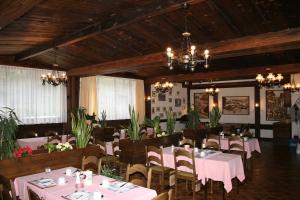 a dining room with pink tables and chairs and chandeliers at Hotel Fiescherhof in Fiesch +45 photos