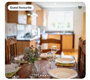 a dining room table with wine glasses and flowers on it at Kirkar Flat in Penton Mewsey