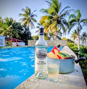 Una botella de agua y un bol de fruta junto a una piscina. en Jubilee Campsite Swim & Paint, en Las Piedras