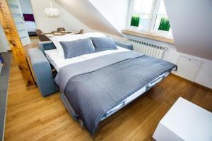 a bedroom with a large bed with blue pillows at Apartamenty SaltApart in Wieliczka
