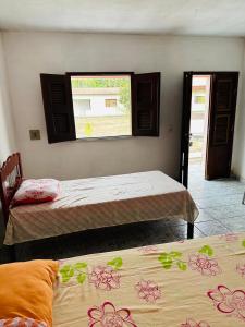 zwei Betten in einem Zimmer mit Fenster in der Unterkunft Pousada o Rancho in Jijoca de Jericoacoara