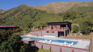 a house with a swimming pool in front of a mountain at Crepúsculo Serrano in Merlo
