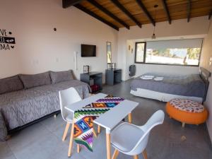 een woonkamer met een bed, een tafel en stoelen bij Crepúsculo Serrano in Merlo
