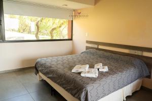 een slaapkamer met een bed met twee handdoeken erop bij Crepúsculo Serrano in Merlo