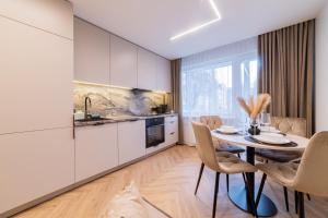 een keuken en eetkamer met een tafel en stoelen bij ENZO Apartments in Šiauliai