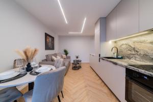 een keuken en woonkamer met een tafel en stoelen bij ENZO Apartments in Šiauliai +20 foto's