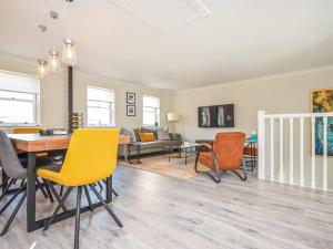 Una sala de estar con sillas amarillas y una mesa. en The White House, en Callander