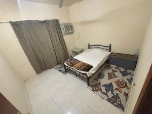 a small bedroom with a bed and a rug at AJMAN HOME Stay ONLY FOR COUPLES FAMILY AND LADIES in Ajman 