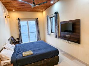 a bedroom with a bed and a flat screen tv at Coffee valley resort Yercaud CVR in Yercaud