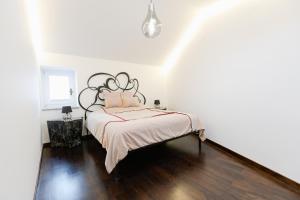 a white bedroom with a bed with a black headboard at Casa Matteo Piran in Piran