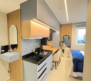 a kitchen and living room with a bed in a room at Studio Moderno com Piscina a 15min a pé do Nubank Parque-117 in São Paulo