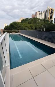 a swimming pool on the roof of a building at Studio Moderno com Piscina a 15min a pé do Nubank Parque-117 in São Paulo
