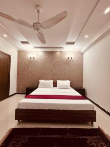a bedroom with a bed with a ceiling fan at Hill Town Family Suites in Islamabad +8 photos