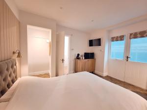 een slaapkamer met een groot wit bed en een televisie bij The Mews Room at The Coach House in Windermere +13 foto's