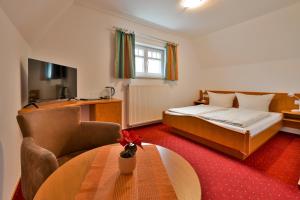 een hotelkamer met een bed en een tafel bij Hotel Waldschlösschen und Spezialitätenrestaurant in Oberhof