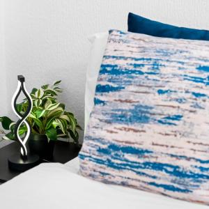 a pillow sitting on a bed next to a plant at Modern Apartment - Accommodates 4 - On Street Parking - Neftlix 2CR in Birmingham