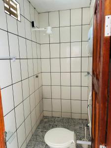 ein weiß gefliestes Bad mit WC in der Unterkunft Pousada o Rancho in Jijoca de Jericoacoara + 17 Fotos