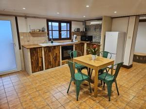 a kitchen with a table and chairs and a refrigerator at Maison au calme 2 logements Guéret in Guéret
