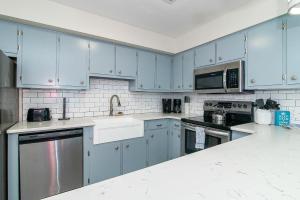 a blue kitchen with stainless steel appliances and blue cabinets at Oceanfront and Modern Top Location on Ocean Blvd w Pool in Myrtle Beach