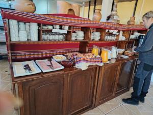 een man die voor een toonbank staat met eten bij Inkas Hotel Cusco in Cuzco