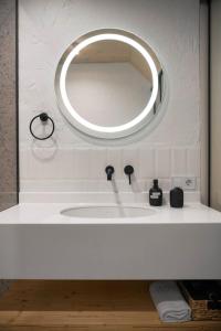 a bathroom sink with a round mirror above it at Samatha space in Slavske
