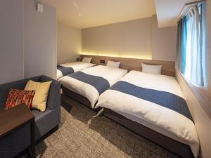 a room with two beds and a couch in it at New Osaka Hotel in Osaka