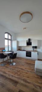 a kitchen with white cabinets and a table and chairs at FewoNr9 in Magdeburg