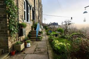 einen Steinweg neben einem Haus mit Pflanzen in der Unterkunft Nursery House Retreat in Heptonstall