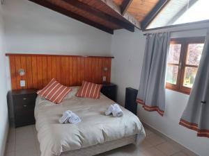 a bedroom with a bed with two towels on it at CASA los ciruelos in El Bolsón