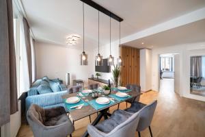 a living room with a table and a blue couch at Altstadt-App. Domblick! in Salzburg