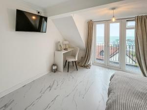 una camera da letto con un letto, una scrivania e una finestra di Oasis a Hythe