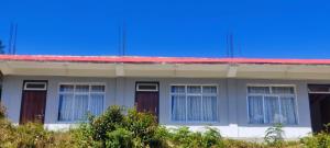 ein Gebäude mit rotem Dach und Fenstern im oberen Bereich in der Unterkunft SILVERBERRY Homestay in Kalimpong + 8 Fotos
