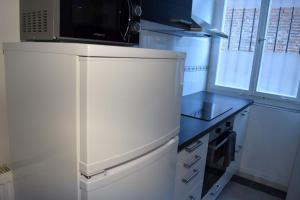 eine kleine Küche mit einem weißen Kühlschrank und einer Mikrowelle in der Unterkunft AB Apartment Objekt 54 in Esslingen