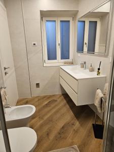 une salle de bain blanche avec un lavabo et des toilettes dans l'établissement Teuta, à Nago