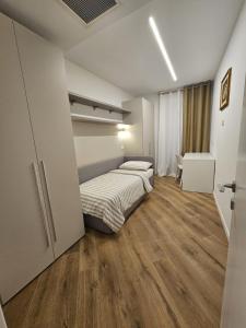 - une chambre avec 2 lits dans une chambre dotée de parquet dans l'établissement Teuta, à Nago