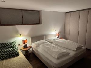 a bedroom with a large white bed and two lamps at Apartment Chalet Ambros in Lech am Arlberg