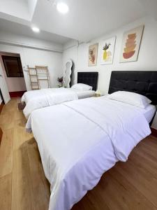 twee bedden in een kamer met witte lakens bij Sun Sun Hostel in Pai