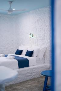 a bedroom with a white bed with blue and white pillows at Sweett Lemon Home in Patong Beach
