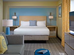 a bedroom with a bed and a couch and a chair at Sonesta ES Suites Omaha in Omaha