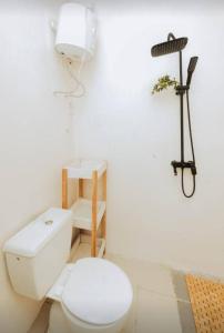 a bathroom with a toilet and a light on the wall at Jed Apartment in Lomé