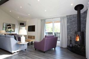 a living room with a couch and a fireplace at Ardeonaig Rock in Morenish