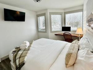 a bedroom with a white bed and a desk and windows at Pony Trail in Collingwood +108 photos