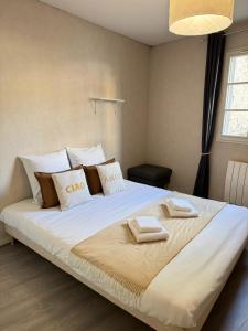 een slaapkamer met een groot bed met twee handdoeken erop bij Rives Bleues by PRIM0 C0NCIERGERIE in Pont-du-Château