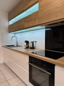 een keuken met een spoelbak en een fornuis bij Rives Bleues by PRIM0 C0NCIERGERIE in Pont-du-Château