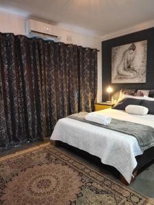 een slaapkamer met 2 bedden, gordijnen en een tapijt bij Vanilla Lee Corporate Suite in Richards Bay