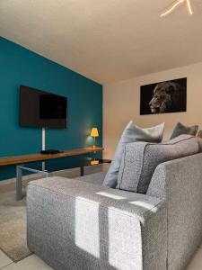 een woonkamer met een bank en een flatscreen-tv bij Rives Bleues by PRIM0 C0NCIERGERIE in Pont-du-Château