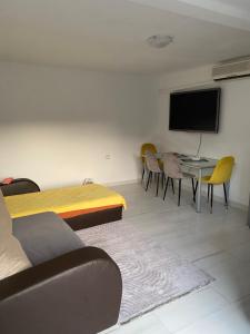 Habitación con mesa, sillas y TV de pantalla plana. en Apartman sa garažom, en Sutomore 7 fotos más